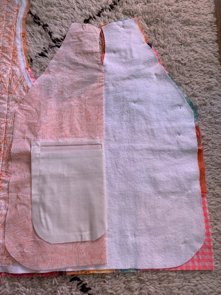 Veste sans manche partiellement matelassée, avec la poche de la doublure repliée.