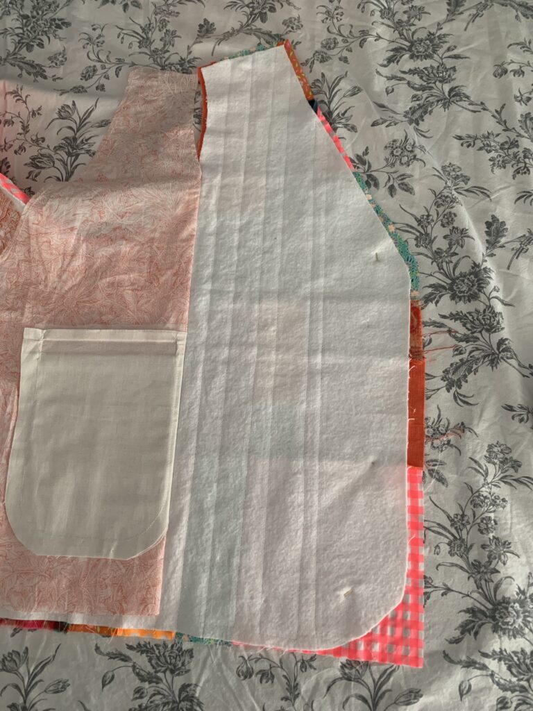 Veste sans manche partiellement matelassée, avec la poche de la doublure repliée.